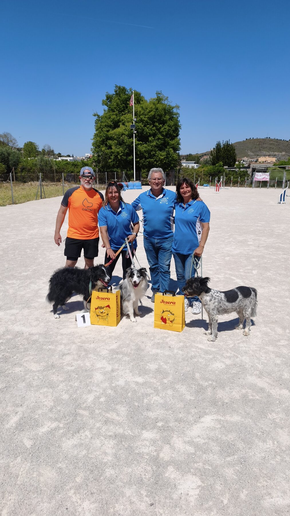 Perros y personas del club junto a los obstáculos
